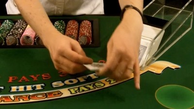 The dealer is taking the card out of the shoe The dealer is taking the card out of the shoe