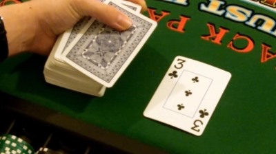 The dealer pushes the top card over a bit The dealer pushes the top card over a bit