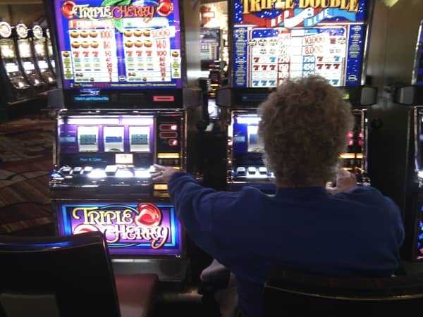 An older woman playing the slots