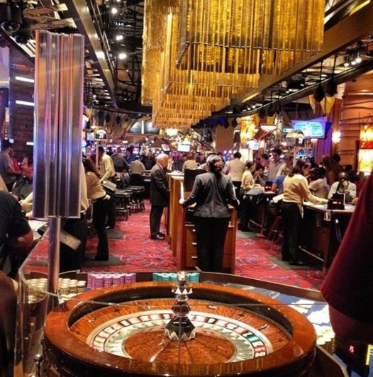 A roulette table with a clear plastic shield guard protecting the wheel