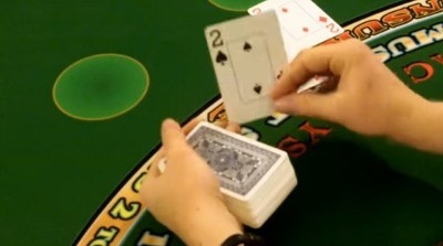 The dealer is hitting the players hand on a handheld deck The dealer is hitting the players hand on a handheld deck