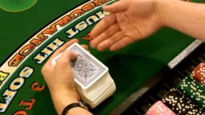 The dealer holds the deck in their dominate hand