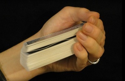 Dealer holding the deck and you can see a waved card in the middle Dealer holding the deck and you can see a waved card in the middle