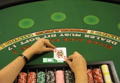 The dealer is taking the card out of the shoe The dealer is taking the card out of the shoe