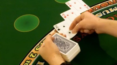 The dealer is hitting the players hand on a handheld deck The dealer is hitting the players hand on a handheld deck