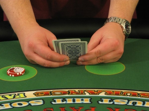 The player is holding the cards with two hands The player is holding the cards with two hands