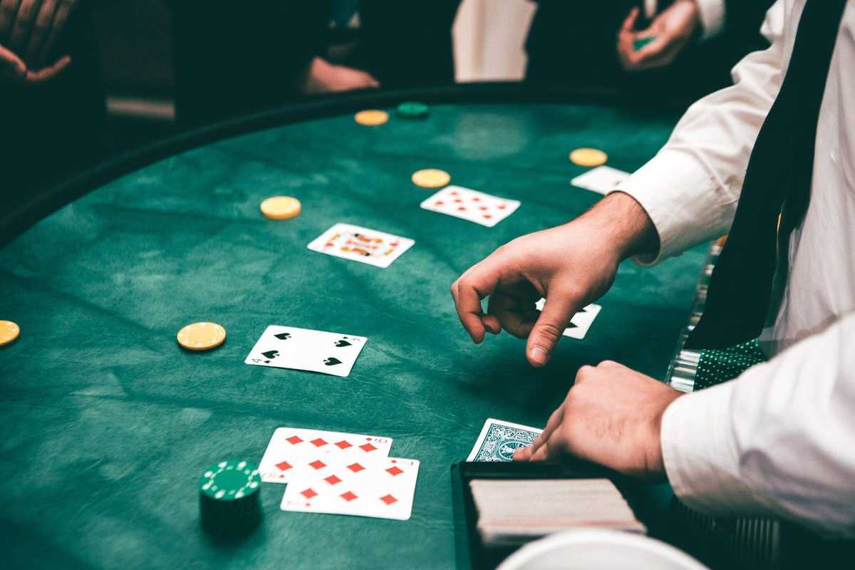 Dealer handles cards at a green felt game table