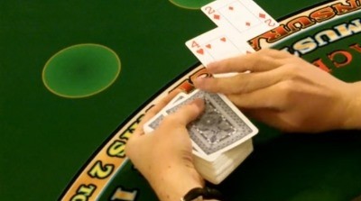 The dealer is hitting the players hand on a handheld deck The dealer is hitting the players hand on a handheld deck