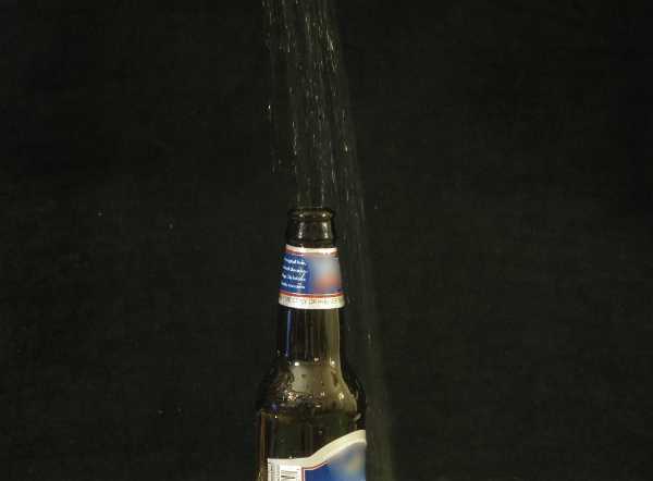 A beer bottle with liquid pouring in it